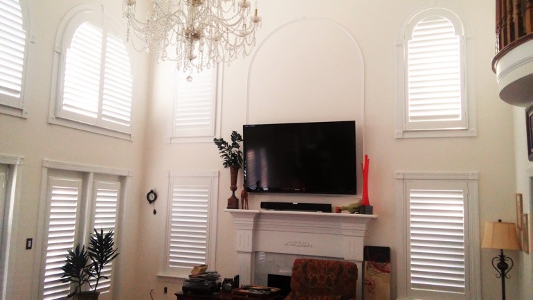 New Brunswick great room with wall-mounted television and arched windows.